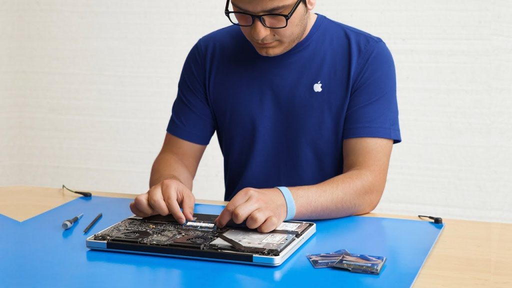 An Apple Genius performing a repair on MacBook Pro 15" An Apple Genius performing a repair on MacBook Pro 15"
